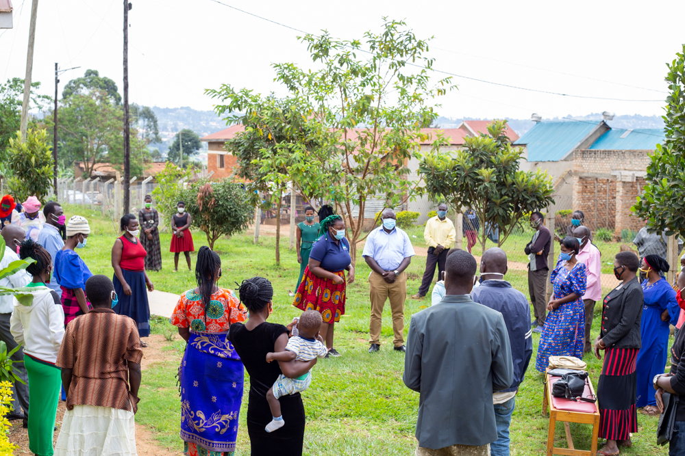 Community members gather in a grassy outdoor space for a group activity.